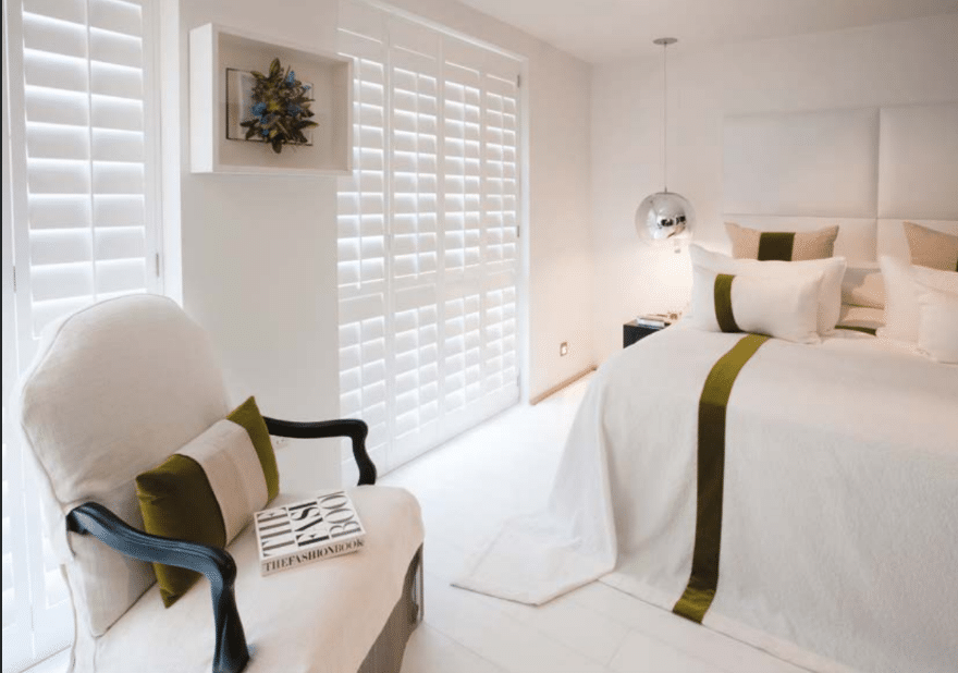 White plantation shutters in a bright bedroom